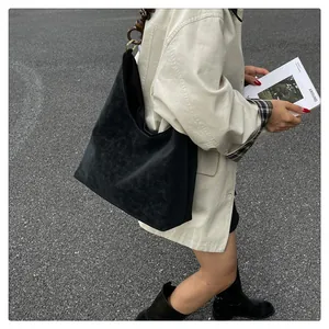 Détail du sac hobo avec de grosses perles marron et des anneaux dorés sur la bandoulière