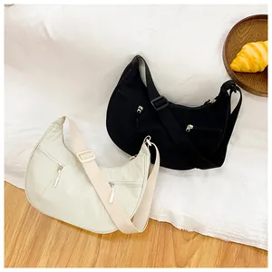Minimalist nylon crescent crossbody bags in black and beige with dual zipper pockets