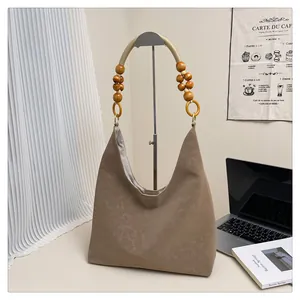 Detail der khakifarbenen Kunstledertasche mit Holzperlengriff und geflochtenem Seil-Design