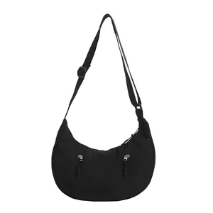 Minimalist black nylon crescent bag with adjustable strap and functional dual zipper pockets