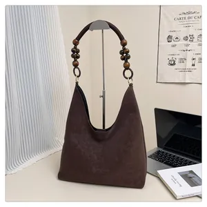 Detail der dunkelbraunen Hobo-Tasche mit Retro-Holzperlen und gewebtem Seilgriff-Design