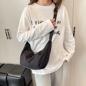 Minimalist black crescent shoulder bag with adjustable strap and drawstring detail