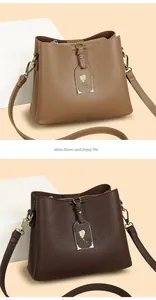 Détail de sacs bandoulière en cuir grainé avec fermetures dorées et pendentifs floraux