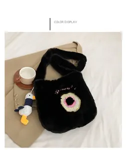 Detail view of black faux fur tote bag with pink donut embroidery and a cute duck pendant
