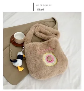 Detail of khaki plush tote with rainbow doughnut embroidery and seagull charm decoration