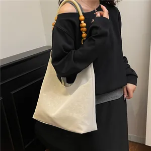 Schicke cremefarbene Hobo-Tasche mit Holzperlenriemen und eleganter Faltenstruktur