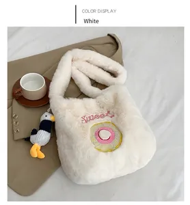 Detail of white plush shoulder bag with Sweet embroidery and cute seagull charm