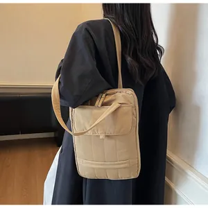 Detail of khaki quilted shoulder bag with vertical texture and front flap pocket