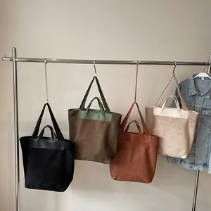 Large corduroy tote bags for women in four colors hanging on a minimalist display rack