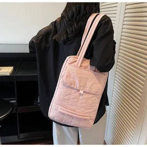 Detail showing high-capacity pink quilted tote bag with front pocket and shoulder straps
