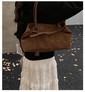 Close-up of caramel vintage leather tote bag with leaf decoration in autumn setting
