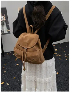 Détail d'un sac à dos vintage en cuir marron avec boucles porté par un mannequin