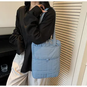 Side view of blue large capacity commuter shoulder bag showing multi-compartment details