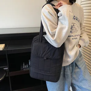 Large black quilted tote bag for commuting with spacious multi-compartment design