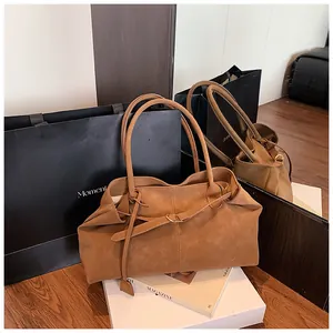 Detail of soft brown oil wax leather tote bag with elegant decorative straps and stitching