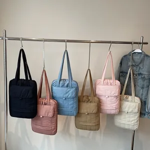 Quilted large capacity laptop bags in six assorted colors hanging on a metal rack