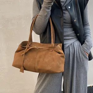 Vintage brown oil wax leather tote bag shown on model with shoulder strap and gold buckle