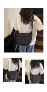 Detail view of the black nylon crescent crossbody bag with minimalist stitching and zipper