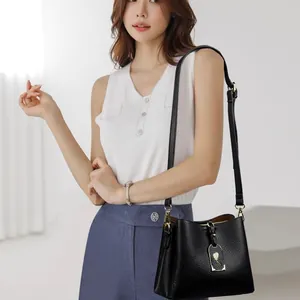 Sac seau noir en cuir pour femme avec bandoulière réglable et détails dorés chics