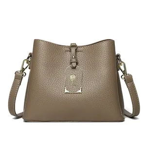 Sac seau rétro en cuir taupe avec pendentif rose dorée et bandoulière chic