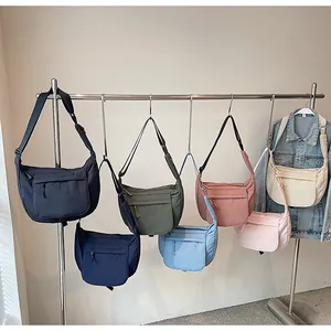 Detailed close-up of colorful waterproof nylon crescent crossbody bags hanging on a rack