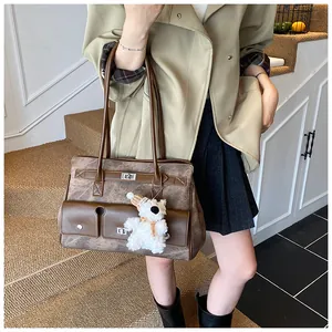 Vintage brown leather tote bag with a cute plush bear pendant shown in a lifestyle setting