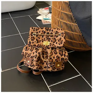 Detail of leopard print backpack featuring quilted stitching and golden chain accents
