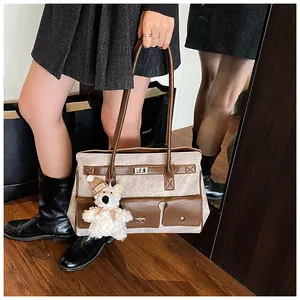 Detail of vintage canvas tote bag with brown leather trim and cute bear charm