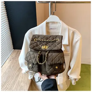 Detail of dark brown quilted backpack with gold hardware and chain straps