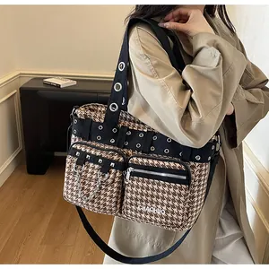 Detail of retro houndstooth crossbody bag with silver chains, rivets and dual pockets