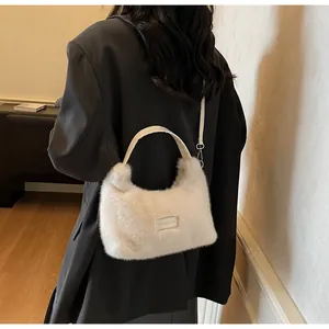 Détail du sac à main en peluche ivoire avec bandoulière fine en similicuir blanc