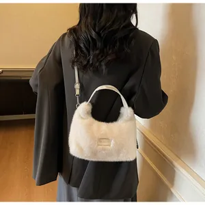 Détails de la texture en fausse fourrure et étiquette sur le sac demi-lune blanc