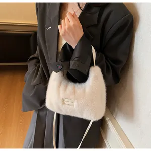 Détail du sac à main en fausse fourrure crème avec étiquette et texture pelucheuse