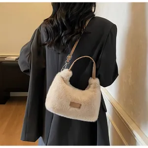 Vue arrière d'un mannequin portant le sac bandoulière beige en peluche avec anse en cuir