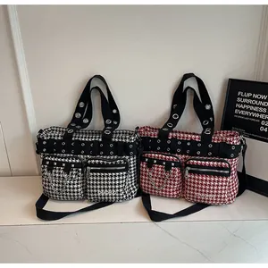 Detail of punk tote bags featuring houndstooth pattern with metal rivets and chains