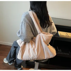 Detail of light pink padded nylon shoulder bag with adjustable drawstring on side