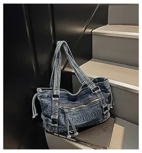 Gros plan d'un sac en denim bleu vintage avec broderie et détails de fermeture éclair
