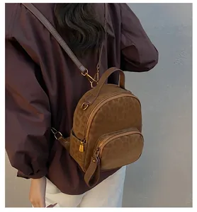 Detailansicht eines Mini-Rucksacks mit Leopardenmuster, Goldreißverschlüssen und Samttextur