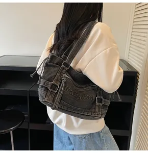 Gros plan détaillé du sac hobo en denim gris anthracite avec poches zippées