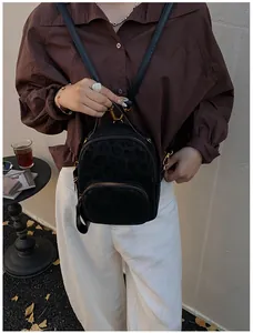 Mini-Rucksack in Schwarz mit Leopardenmuster und goldenen Details, getragen von einem Model