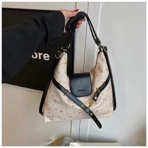 Polka dot canvas shoulder bag featuring a leather flap and elegant gold-tone metal buckle