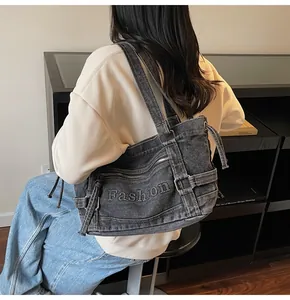 Détail d'un sac cabas en denim délavé gris avec broderie Fashion et fermetures éclair en métal
