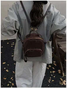 Detailaufnahme eines Mini-Rucksacks mit Leopardenmuster und goldener Hardware am Modell