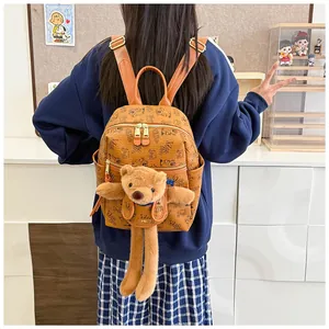 Brown PU leather backpack with cartoon bear prints and cute plush toy worn by a model