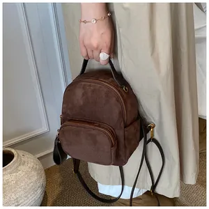 Detailansicht eines braunen Mini-Rucksacks aus mattem Leder mit Vintage-Metallbeschlägen