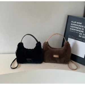 Détail de sacs bandoulière en fausse fourrure noire et marron avec écusson logo