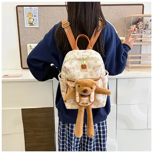 Detail of stylish beige backpack with bear pattern and 3D plush bear charm with NK logo