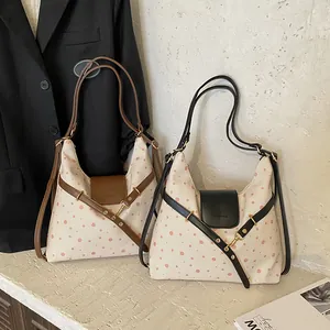 Polka dot canvas shoulder bags in brown and black trim on a minimalist background