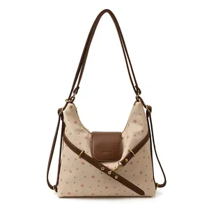 Chic beige canvas shoulder bag with red polka dots and premium brown leather straps