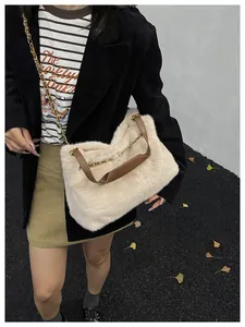 Nahaufnahme der flauschigen cremeweißen Plüschtasche mit Lederriemen und goldener Kette